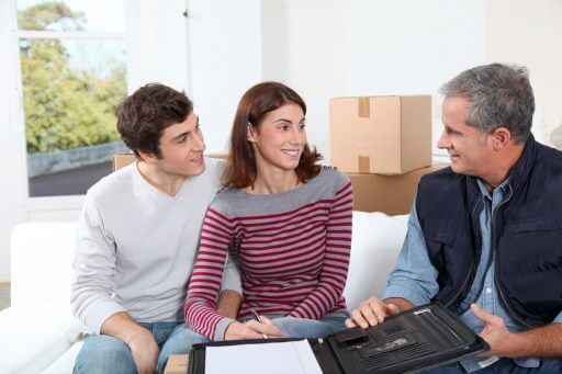 Hire a local moving company, a young couple meets with a professional mover to sign a contract.
