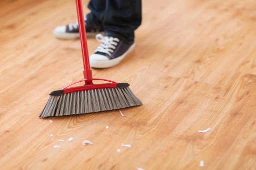 Cleaning a house with a broom after moving with Master Movers